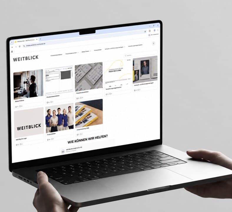 The WEITBLICK media portal on a laptop — tiles with product data sheets, images and sales documents under the WEITBLICK logo